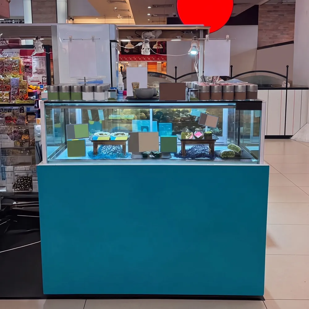 AANRS cake chiller rental Singapore, teal-panelled glass display counter of desserts at a shopping mall kiosk