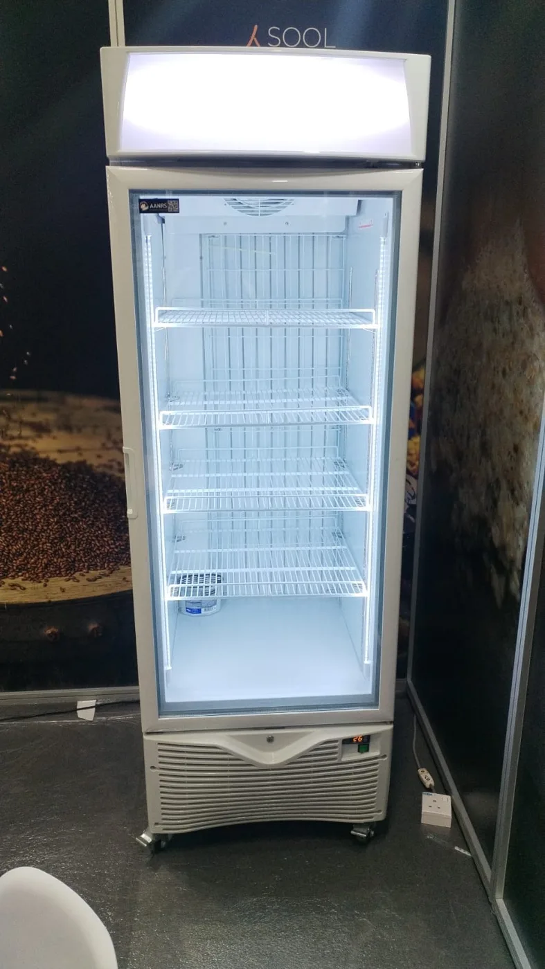 AANRS drink chiller rental Singapore, empty glass-door chiller with a lit header panel standing in a coffee exhibition booth