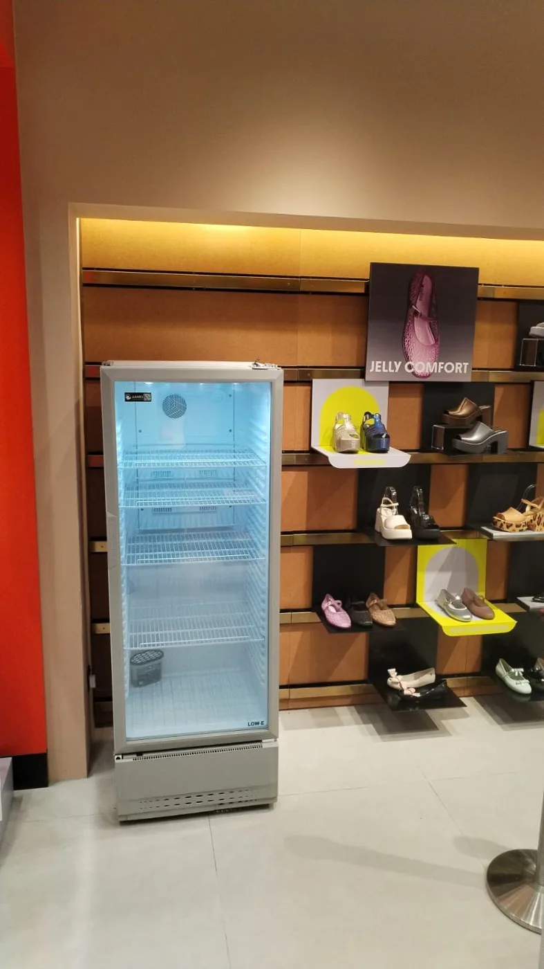 AANRS drink chiller rental Singapore, empty glass-door chiller placed against a lit shoe display wall in a retail store