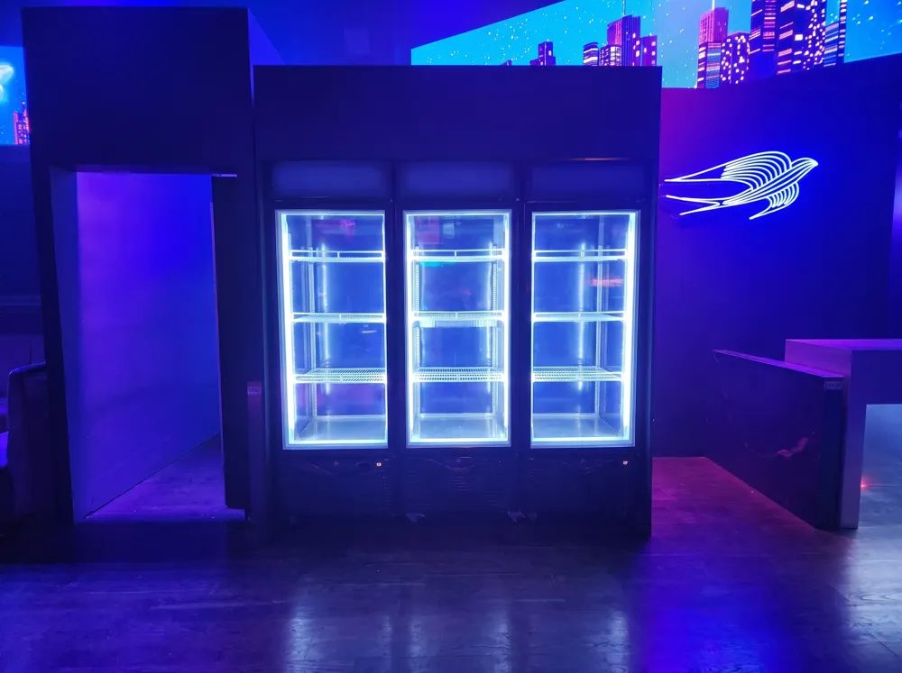 AANRS drink chiller rental Singapore, three-door glass chiller lit up and built into a dark, neon-lit event set